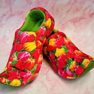 Colourful floral slippers on pink background.