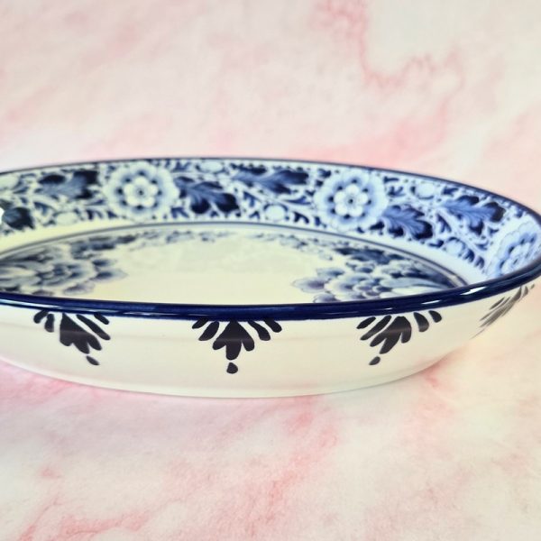 Blue floral ceramic dish on pink background.